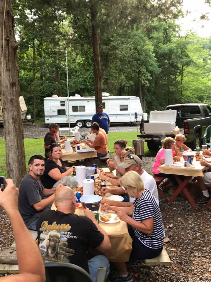 A classic Maryland crab feast set up on a picnic table at Timber Valley Retreat, with steamed Chesapeake blue crabs seasoned with Old Bay on a sunny 100-acre farm.