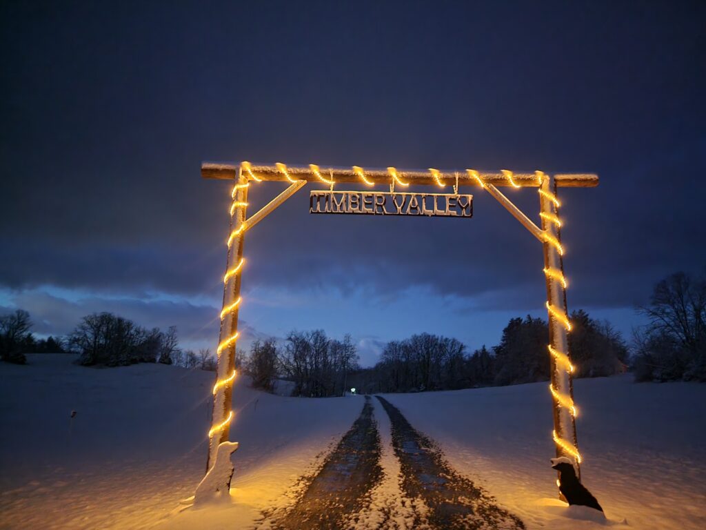 Snow-covered entrance to Timber Valley Retreat at dusk, welcoming guests to a peaceful Maryland Dark Sky Cabin in Western Maryland.