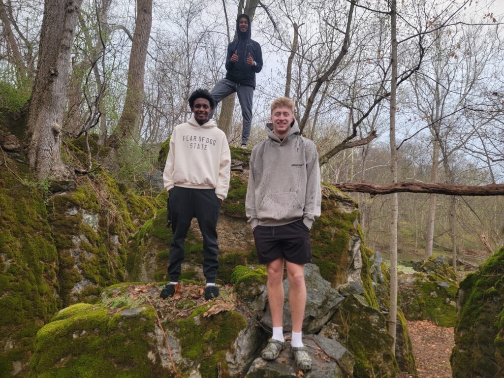 Guests exploring moss-covered boulders at Timber Valley Retreat during a Relaxing Nature Cabin Western Maryland getaway surrounded by peaceful woodland scenery.