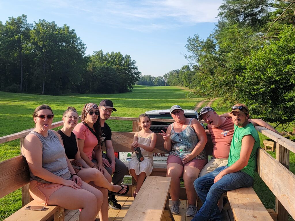 Family enjoying a ride on the Trailblazer Wagon at Timber Valley Retreat, a unique experience during a Family Cabin Getaway Maryland at our Western Maryland Cabin.