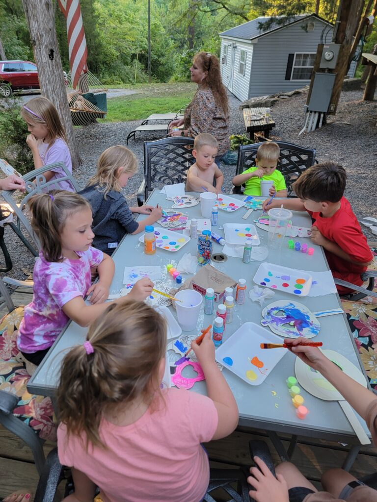 Children and families enjoying a craft activity together during a stay at Timber Valley Retreat in Clear Spring, Maryland, illustrating approved daytime visitors and family-friendly experiences.
