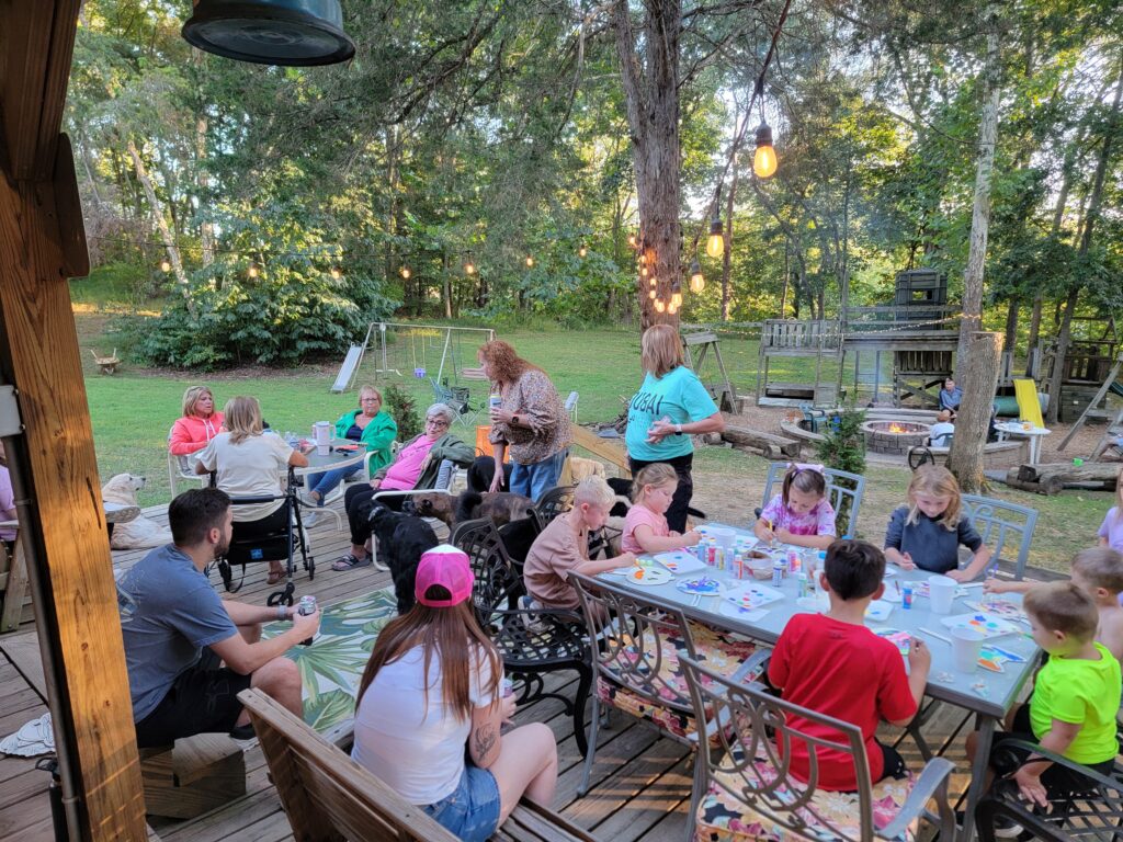 Families enjoying crafts, conversation, and time together on the deck at Timber Valley Retreat during a Family Cabin Getaway Maryland at our Western Maryland Cabin.