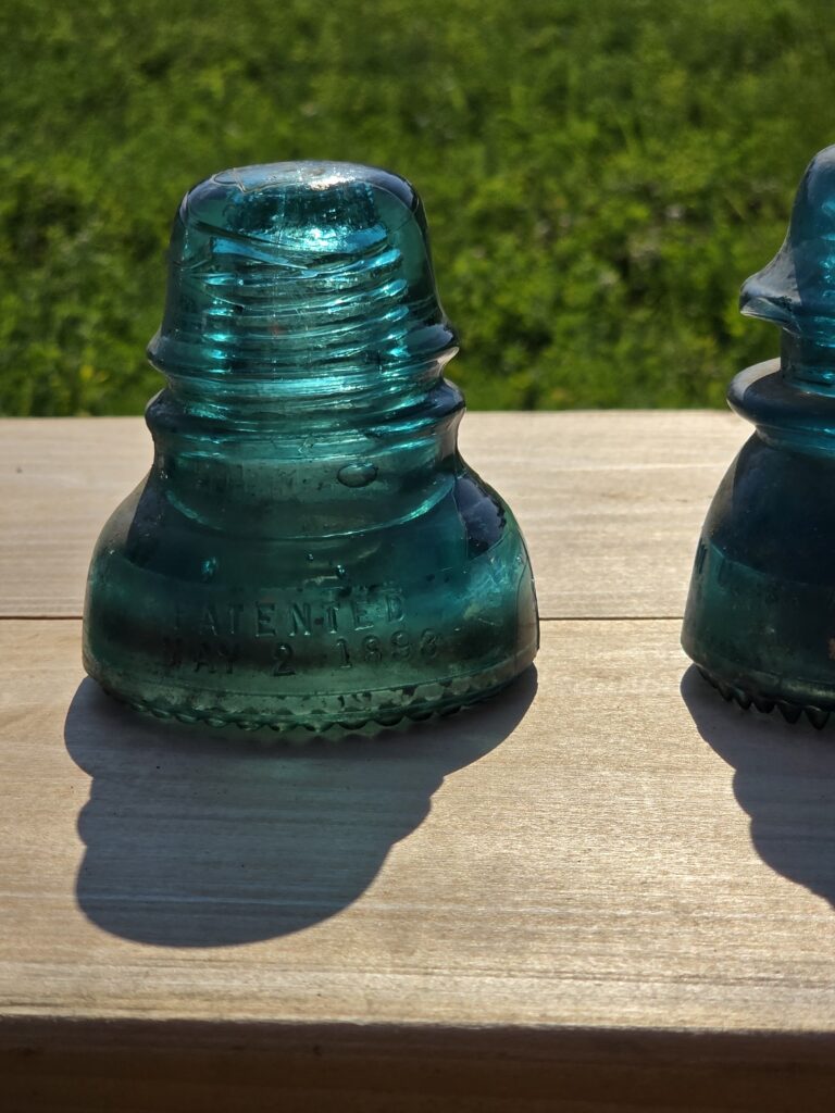Historic glass railroad insulator with Patented May 2, 1893 marking discovered near the railroad corridor at Timber Valley Retreat in Clear Spring, Maryland.