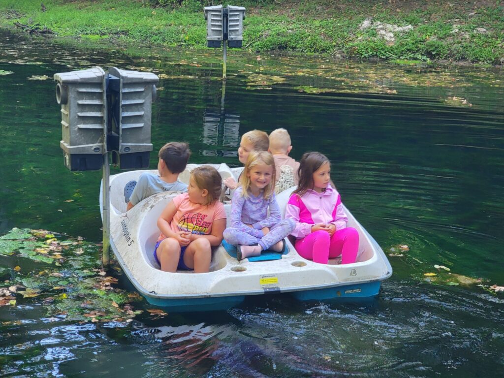Children riding a pedal boat on the spring-fed pond at Timber Valley Retreat during a Family Cabin Getaway Maryland, creating Family Cabin Getaway Memories at our Western Maryland Cabin.
