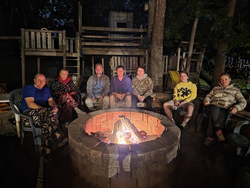 Guests relaxing around a campfire at a Peaceful Woodland Retreat featuring Quiet Cabin Retreat Maryland, Nature Retreat Maryland, and Peaceful Getaway Maryland at Timber Valley Retreat.