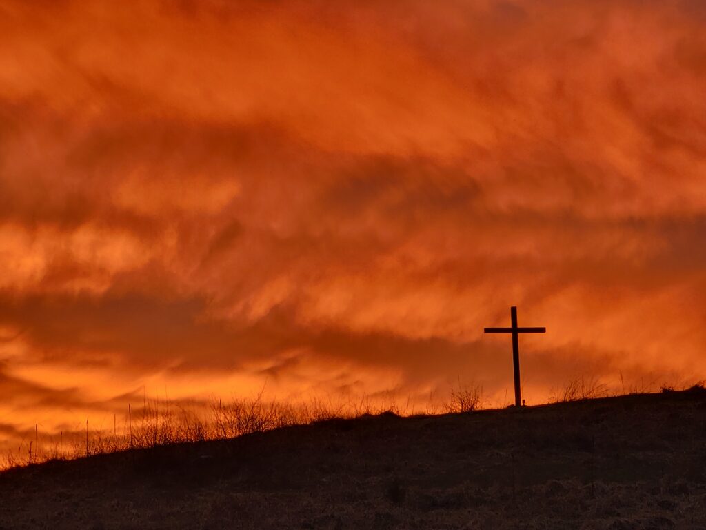 The Cross on the Hill silhouetted against a brilliant sunset at Timber Valley Retreat, an Exclusive Private Cabin Retreat in Washington County, Maryland near Washington DC, Northern Virginia, Pennsylvania, West Virginia, and Maryland's Eastern Shore.