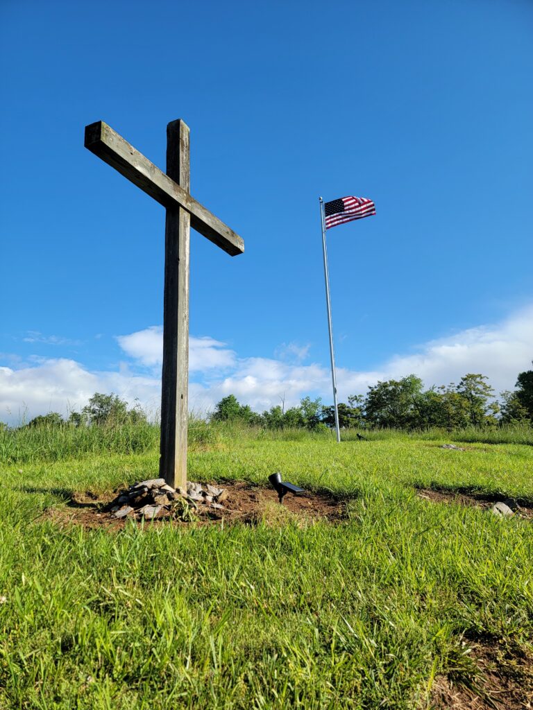 The Cross on the Hill with the American flag overlooking the countryside at Timber Valley Retreat, an Exclusive Private Cabin Retreat in Washington County, Maryland near Washington DC, Northern Virginia, Pennsylvania, West Virginia, and Maryland's Eastern Shore.