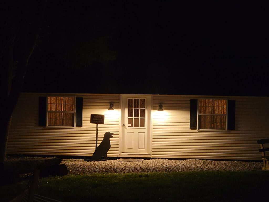 Warmly lit Tanner's Bunkhouse at Timber Valley Retreat during a peaceful evening at an Exclusive Private Cabin Retreat in Washington County, Maryland.
