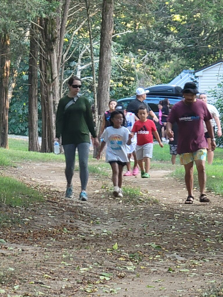 Families walking together along a wooded path at Timber Valley Retreat during a Digital Detox Family Getaway Maryland.