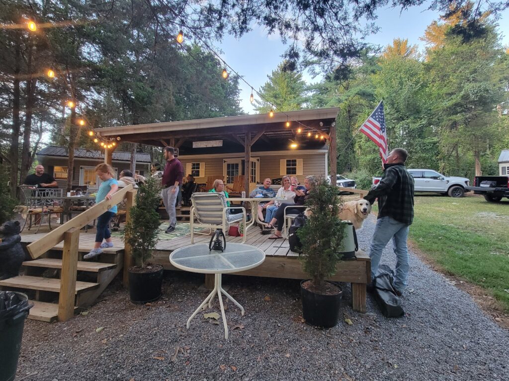 Guests relaxing beneath string lights during a Peaceful Weekday Getaway MD at Timber Valley Retreat, an Exclusive Private Cabin Retreat in Washington County, Maryland.