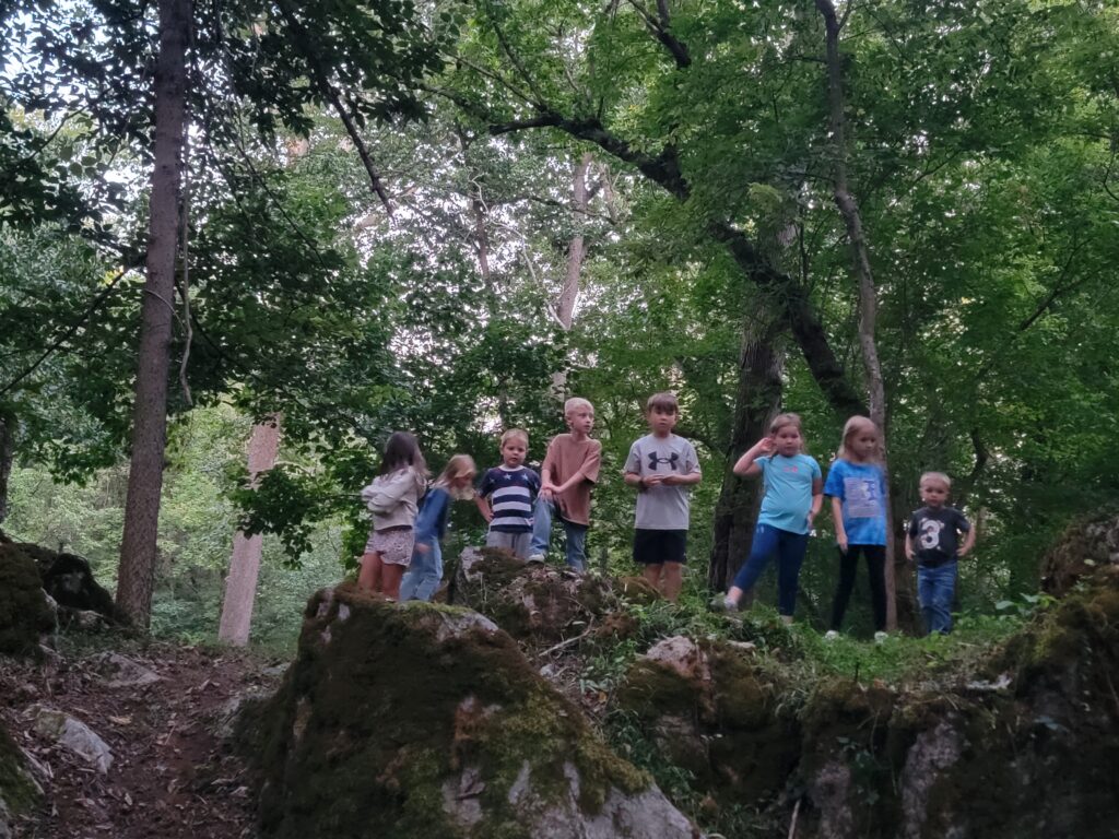 Children exploring moss-covered boulders and woodland trails during a Peaceful Weekday Getaway MD at Timber Valley Retreat in Washington County, Maryland.