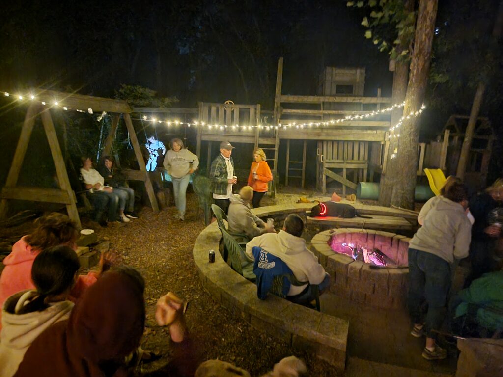 Guests enjoying Evening Reflections around a campfire with string lights at Timber Valley Retreat, an Exclusive Private Cabin Retreat in Washington County, Maryland.