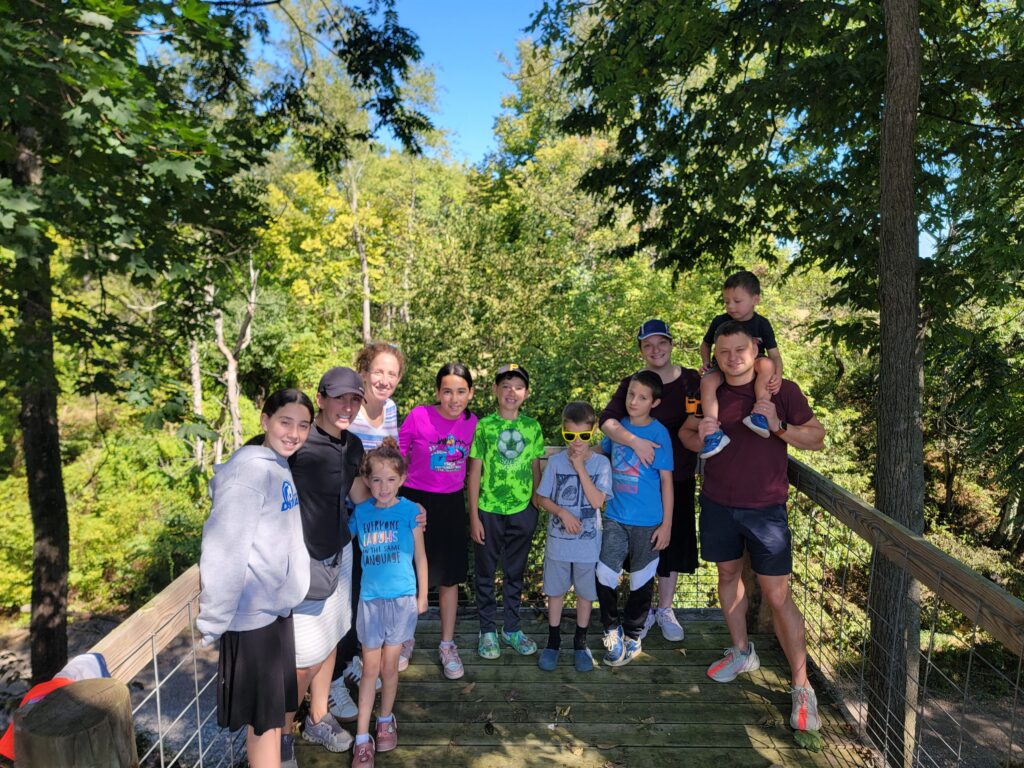 Family group exploring a woodland bridge together at Timber Valley Retreat in Clear Spring Maryland during a nature getaway.