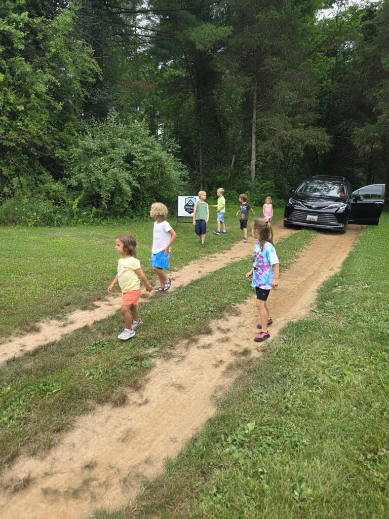 Children walking along a woodland path at Timber Valley Retreat during a Screen Free Family Vacation Maryland.