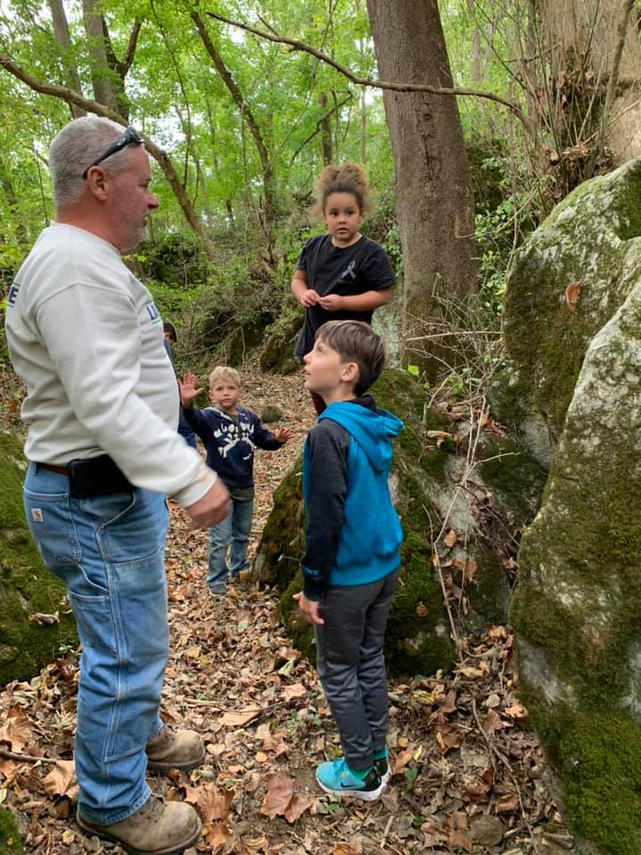 Tom talking with children and answering their questions while exploring the moss-covered boulders in the woodland at Timber Valley Retreat in Clear Spring Maryland.