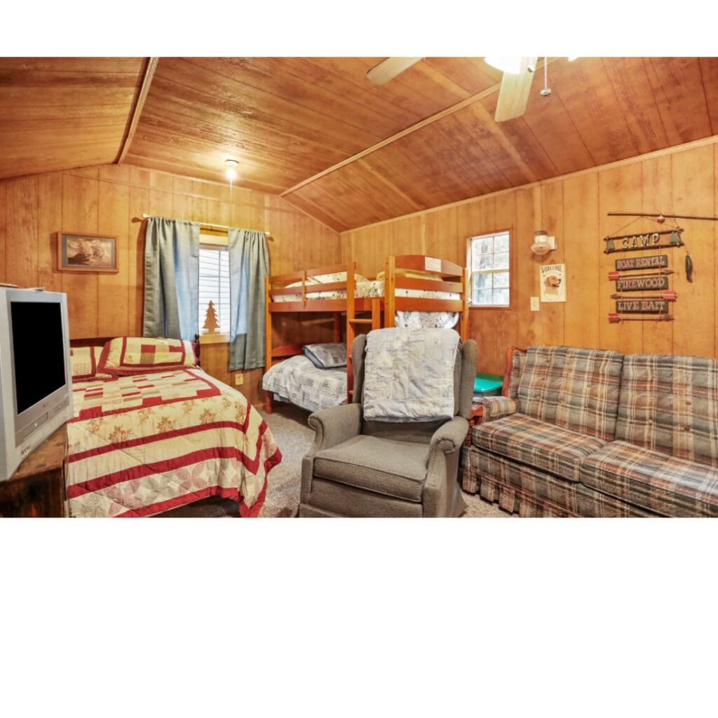 Amber's Lodge interior with beds, bunk beds, sofa and rustic wood-paneled walls at Timber Valley Retreat in Clear Spring Maryland