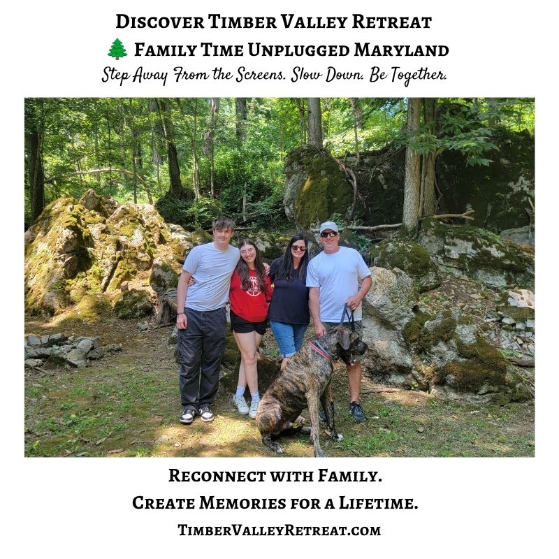 Family spending time together with their dog among moss-covered boulders in the woodland at Timber Valley Retreat in Clear Spring Maryland.