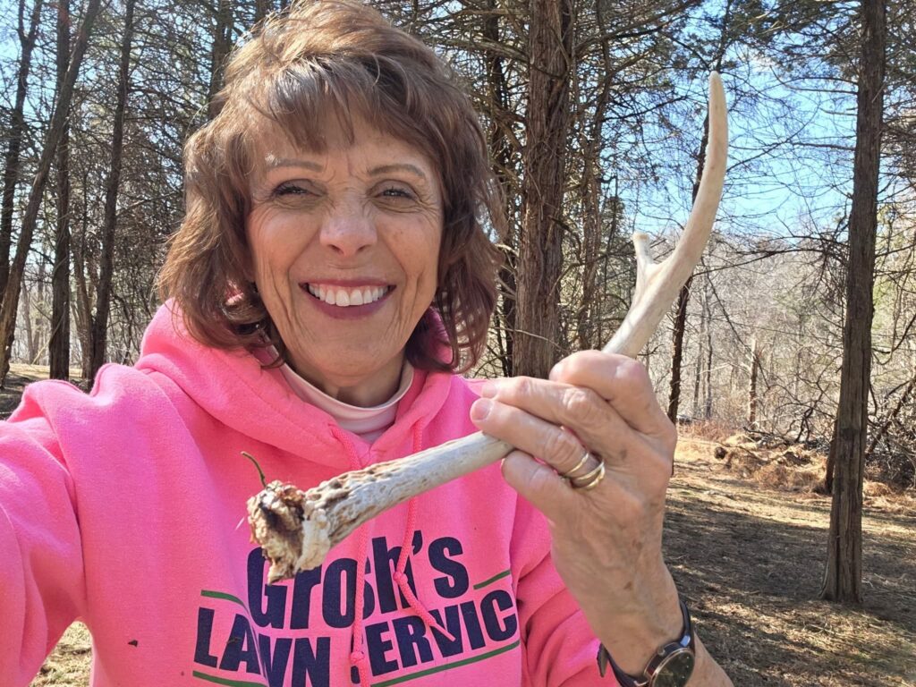Guest discovering a naturally shed deer antler during a Nature Discoveries Maryland walk at Timber Valley Retreat, a Western Maryland Cabin Rental in Washington County.