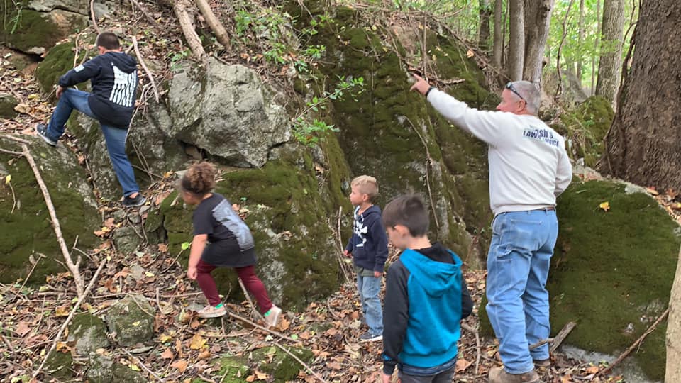 Tom giving guests a tour of the moss-covered boulders in the woodland at Timber Valley Retreat in Clear Spring Maryland.