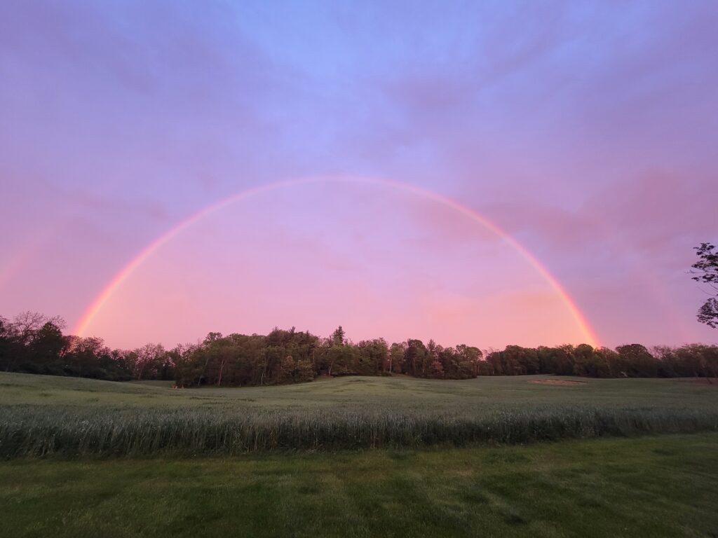 Double Western Maryland rainbow stretching across the rolling hills and countryside at Timber Valley Retreat after a summer storm.