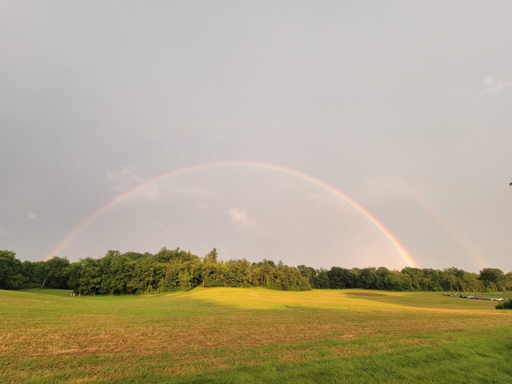 Rainbow over the meadow at Timber Valley Retreat after a summer rain in Western Maryland, showcasing the peaceful countryside.
