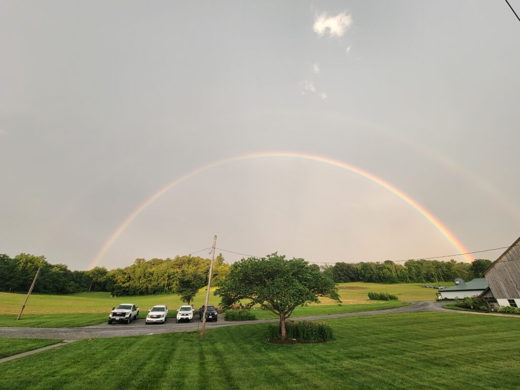 Double rainbow over Timber Valley Retreat in Western Maryland with the barn, meadow, and countryside following a summer rainstorm.