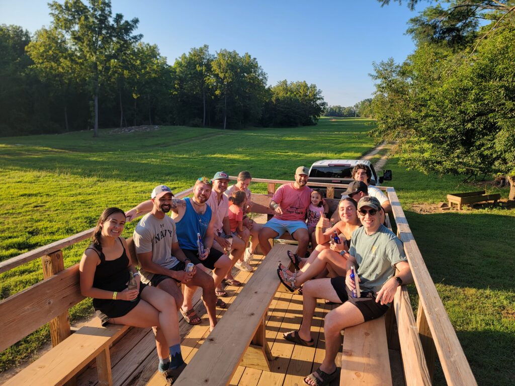 Families enjoying a Trailblazer wagon ride through the scenic meadows at Timber Valley Retreat during a peaceful Western Maryland cabin getaway.
